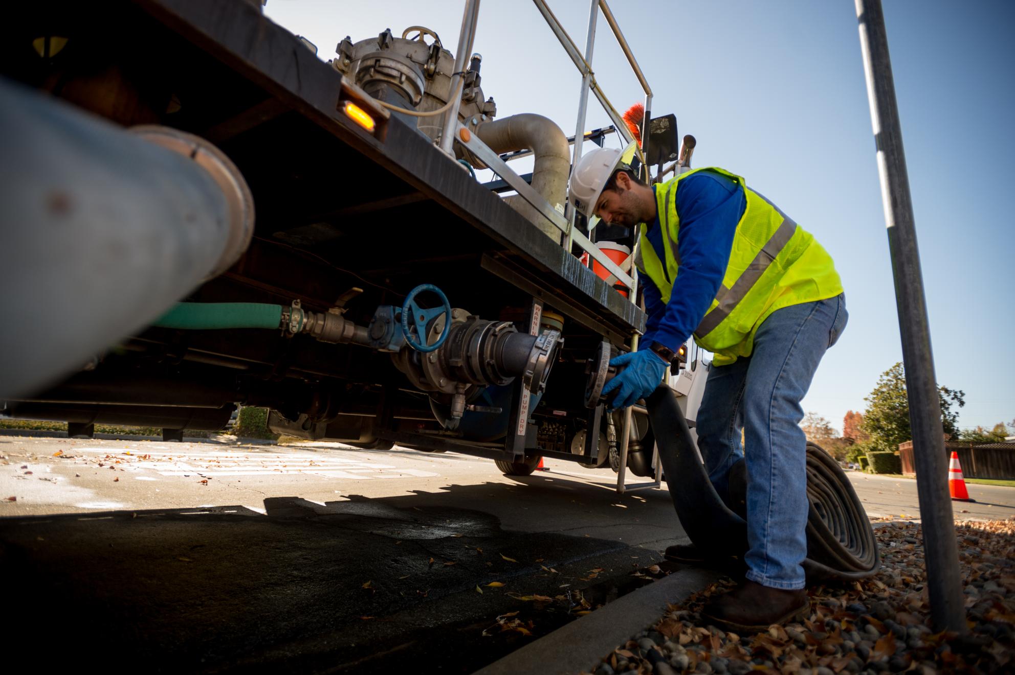 San Jose Water Employee hooking hose up to to machinery