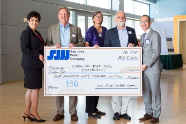1_0.jpg Five smiling executives holding a giant check