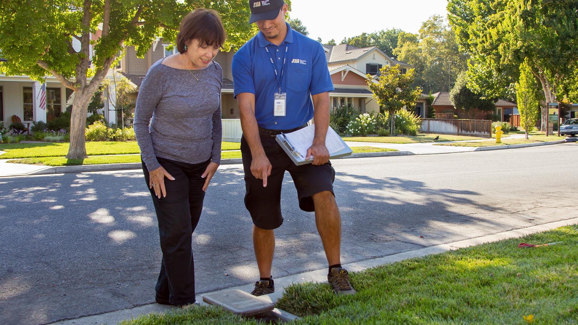 SJW customer and worker outside examining a property.