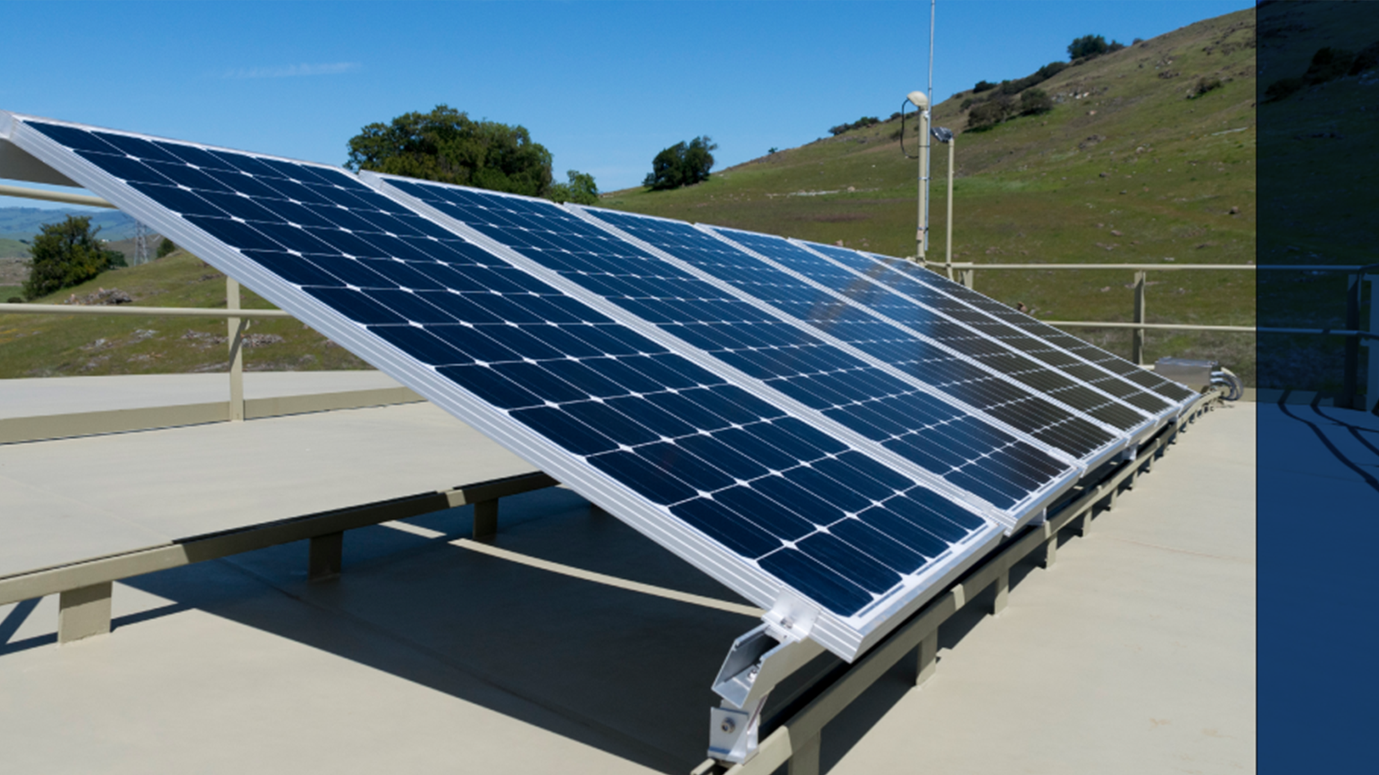 Solar panels on the side of a hill on a sunny day.