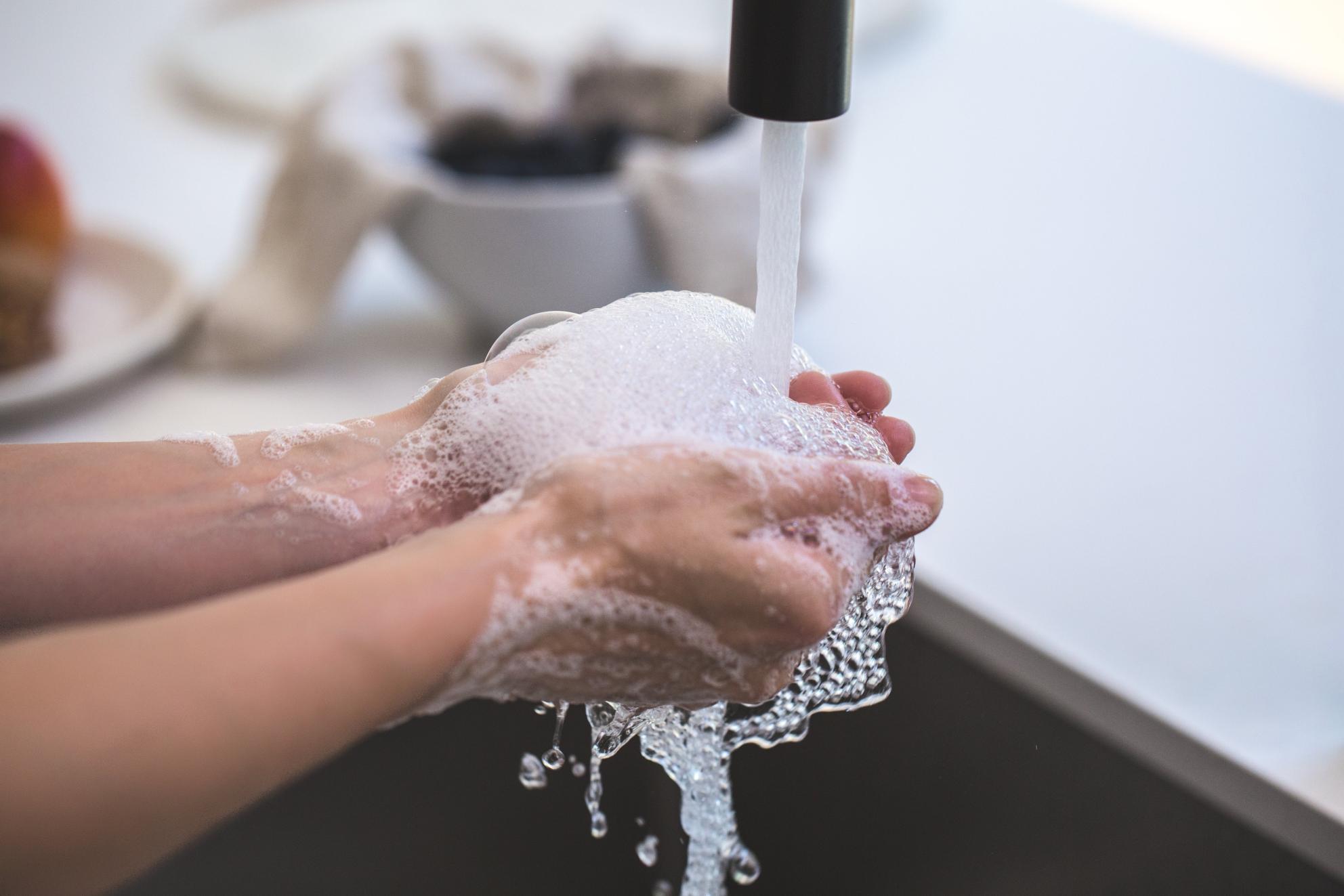 hands under faucet washing