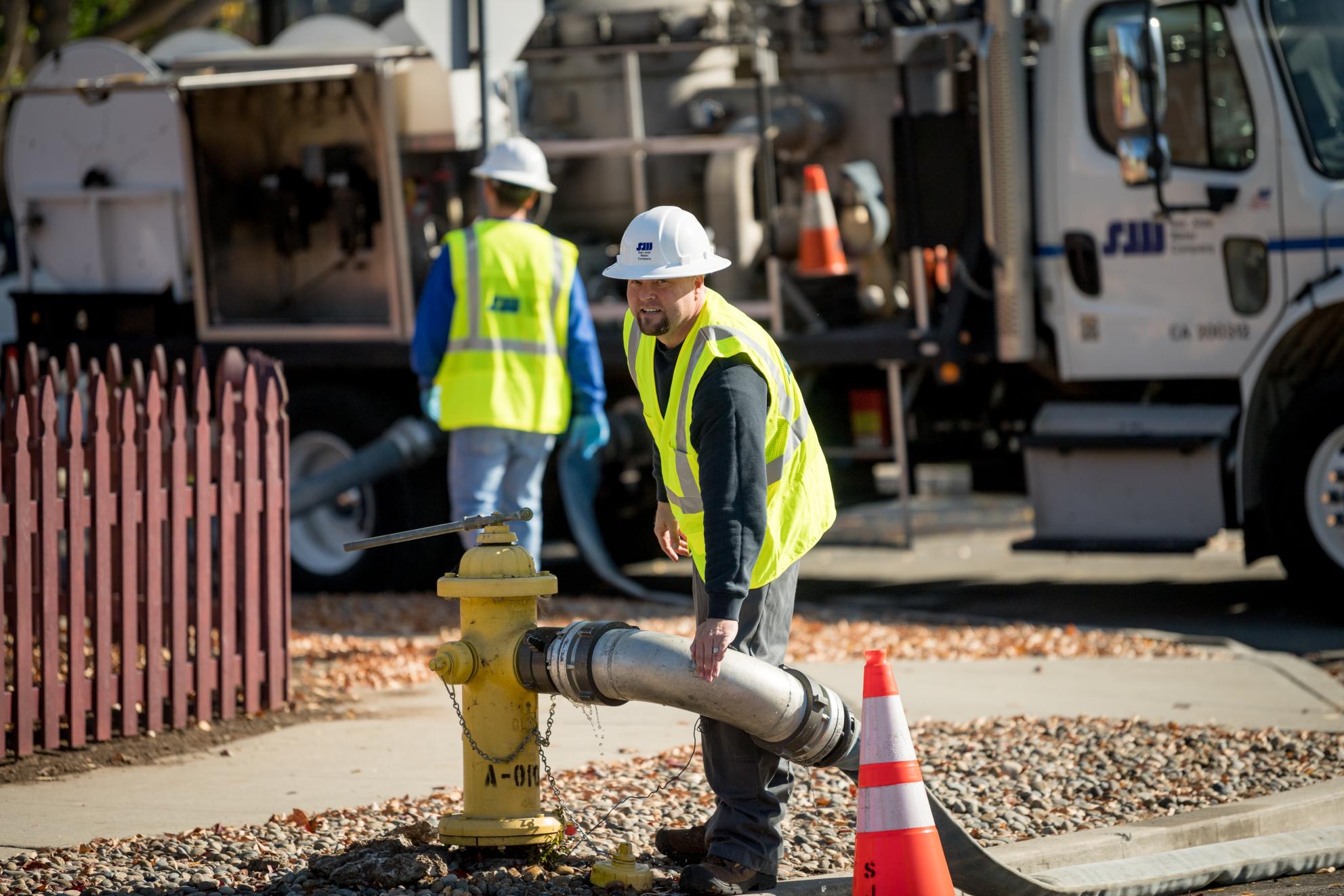 SJW Flushing Truck with Worker adding hose to hydrant