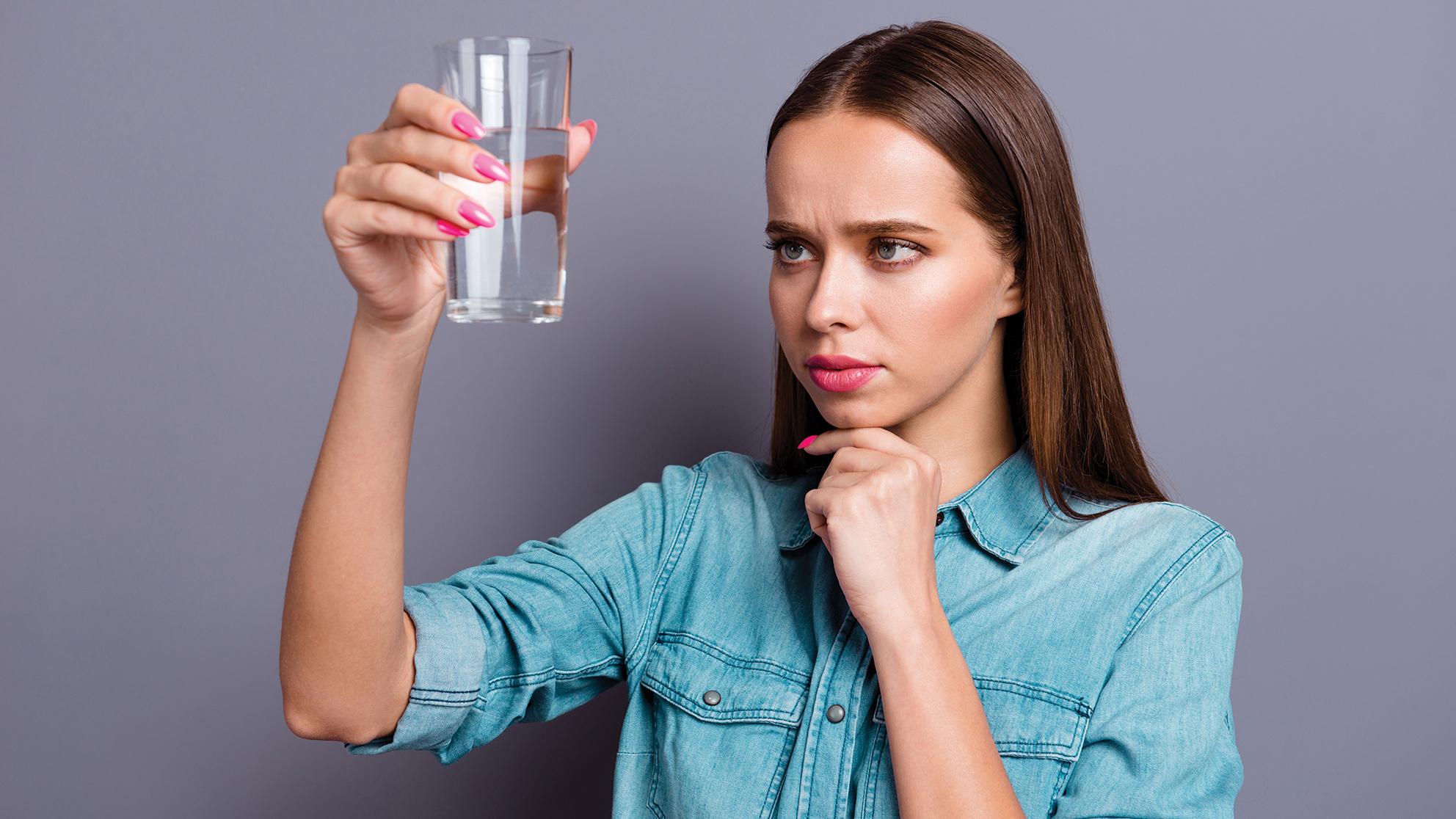 Woman looking at class of water