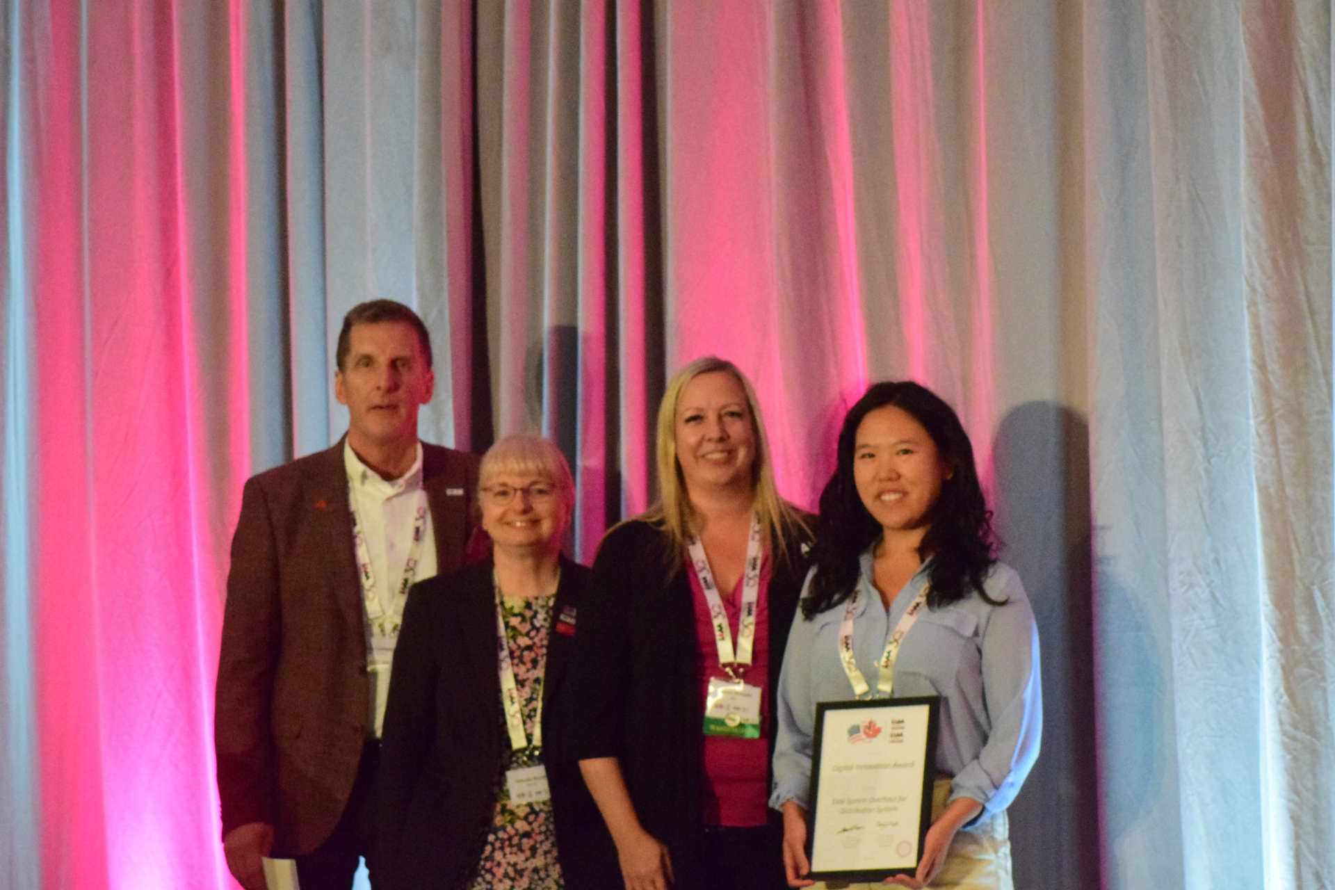 Photo of four members of the asset management team with their IAM award